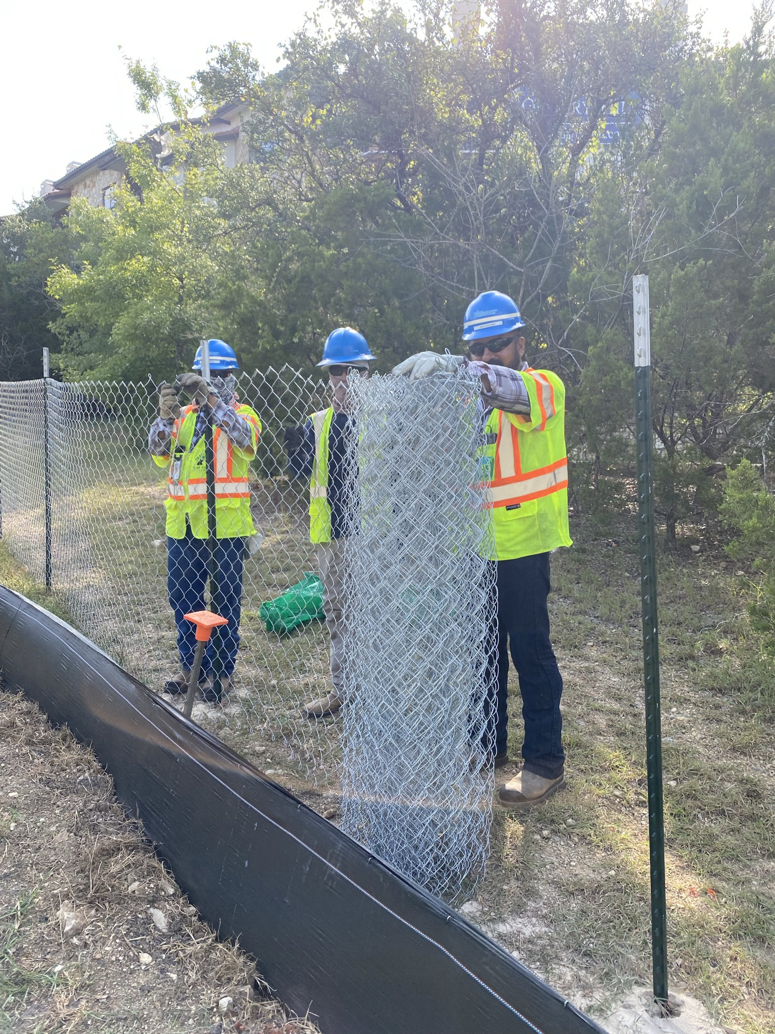 Crews install a fence between the Bell Quarry Hill apartments and state right-of-way off of US 290. Separating construction work areas from nearby apartments, homes and businesses are some important safety measures taking place before major work on Oak Hi